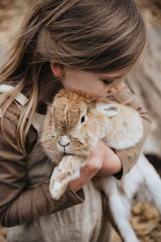 Mädchen kuschelt sich an Hasen