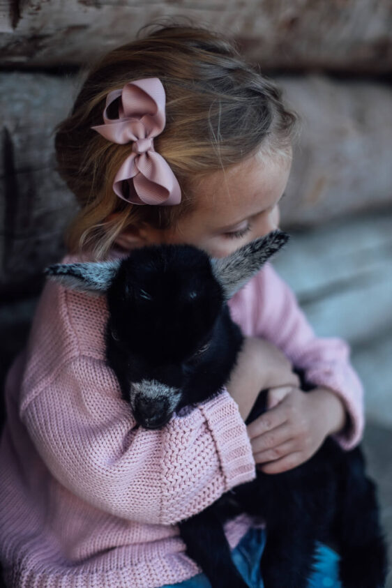 Mädchen kuschelt Ziege