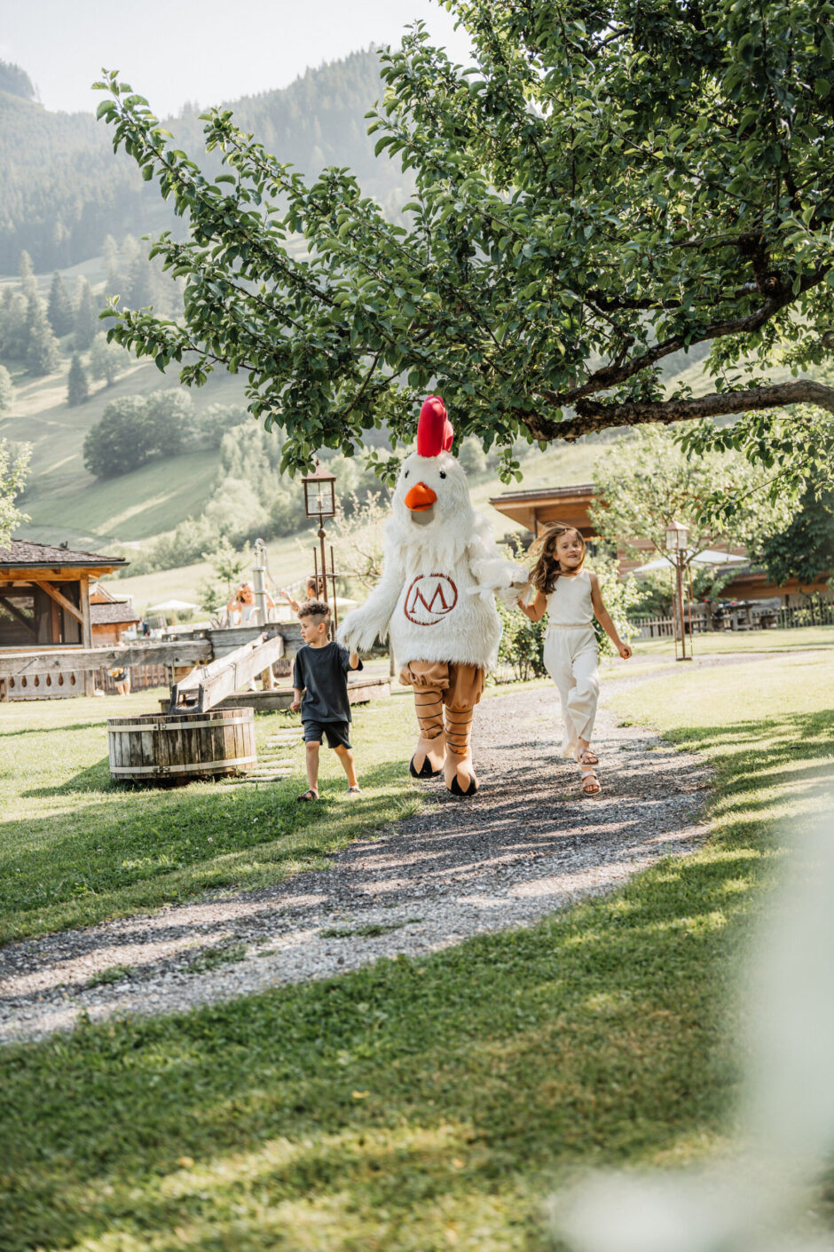 Kinder gehen mit Gusti durch den Garten