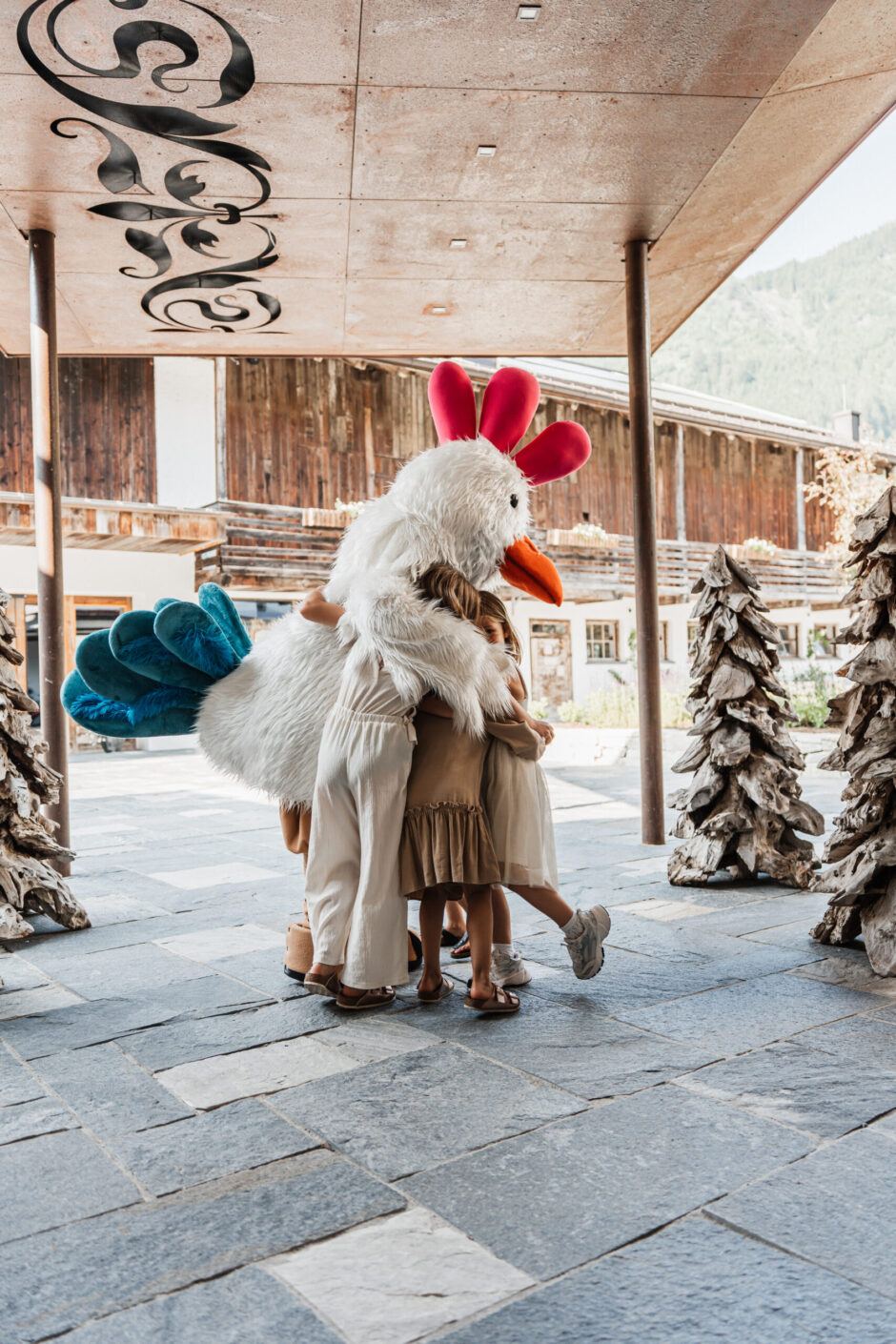 Maskottchen Gusti umarmt Kinder