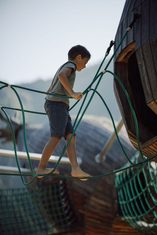 junge Klettert am Moar Gut Spielplatz